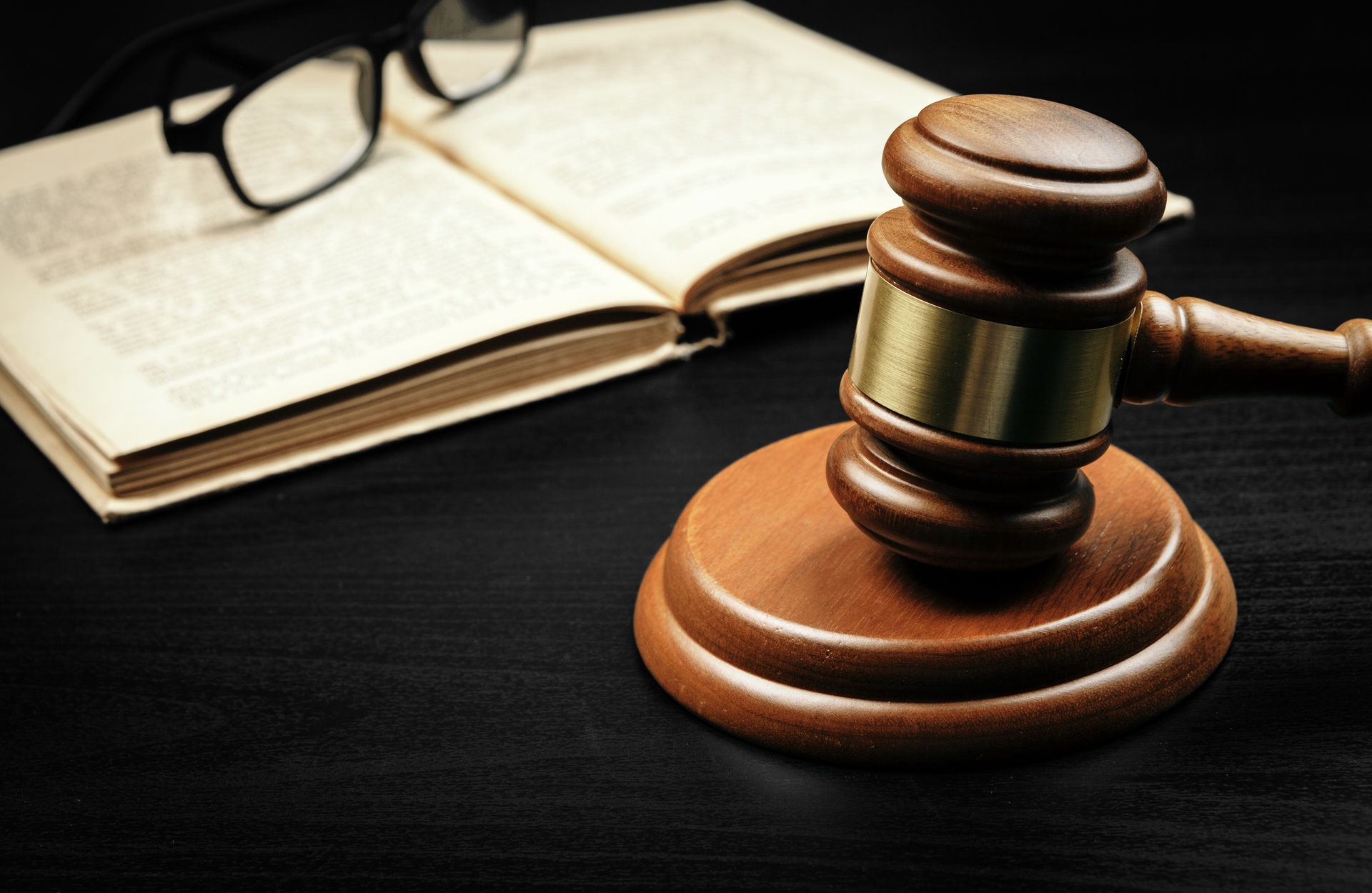 Abogados con experiencia en derecho penal en Betxí. Mallete junto a unas gafas sobre un libro.