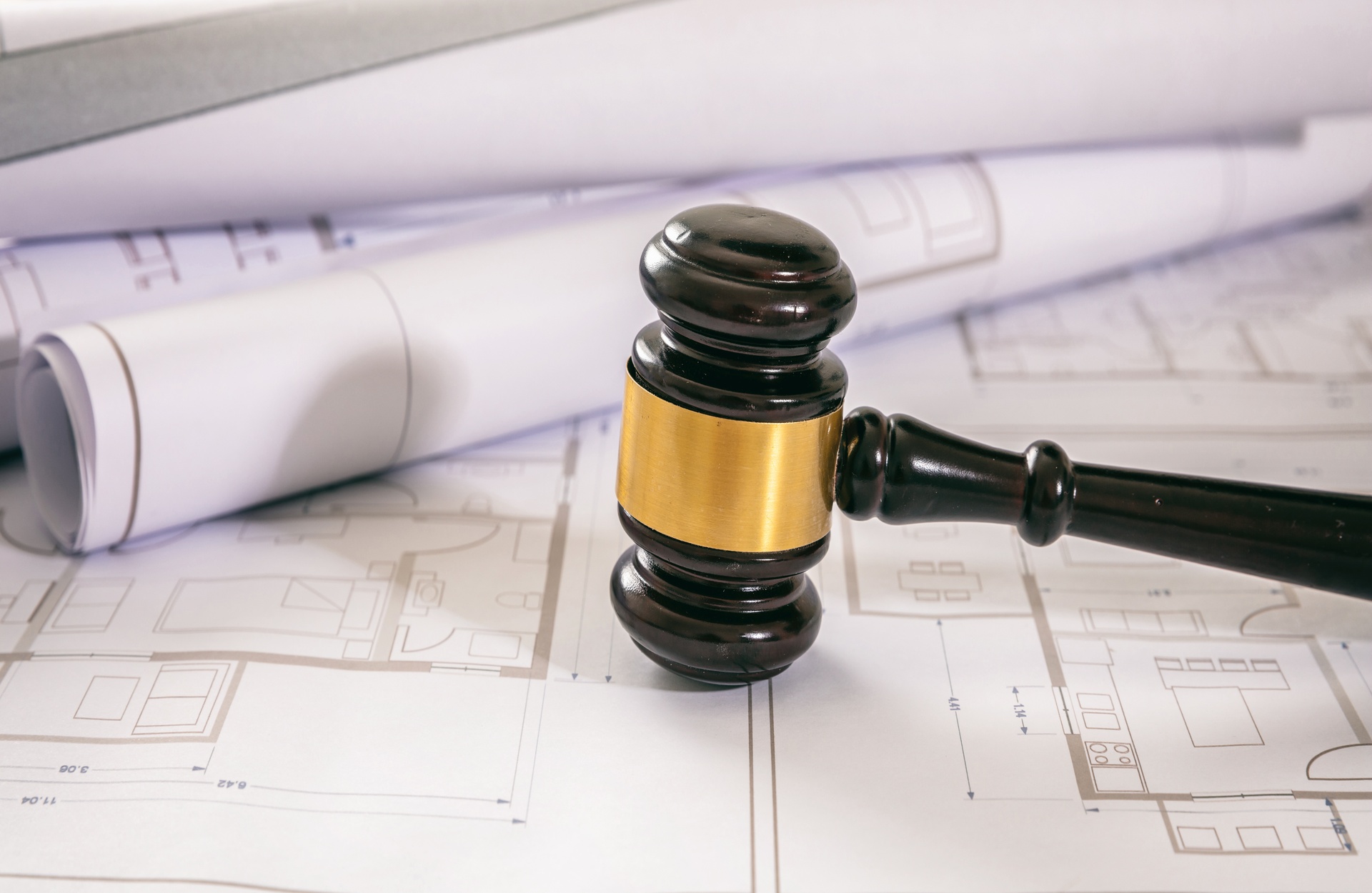 Abogados con experiencia en derecho penal en Mas de Flors. Mallete sobre unos planos de una estructura.