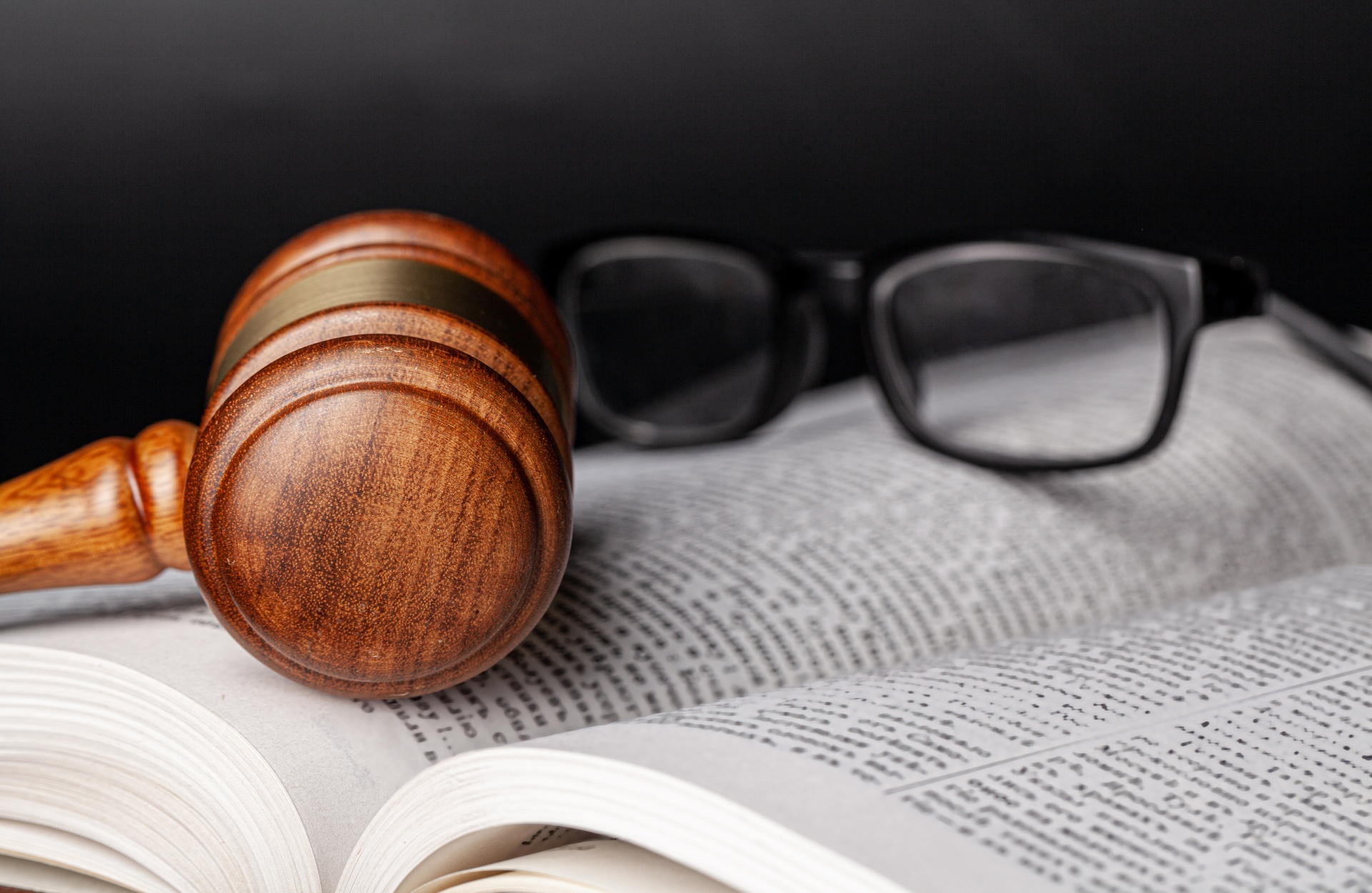 Capillartiga abogados, abogados expertos en derecho civil en Grao de Castellón. Mallete sobre un libro con unas gafas.