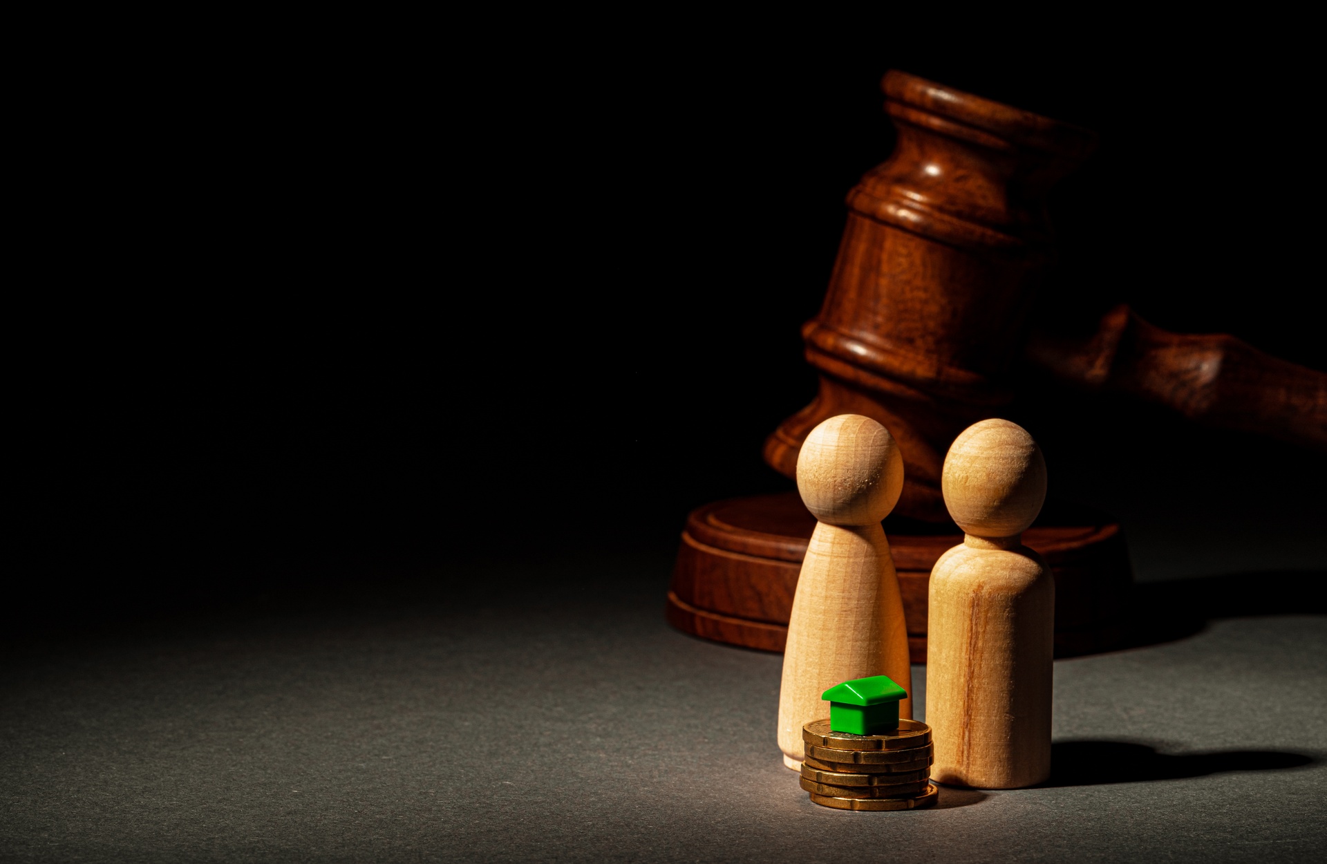 Capillartiga abogados, abogados expertos en derecho civil en Las Palmas. Dos figuritas de madera junto a una propiedad verde.